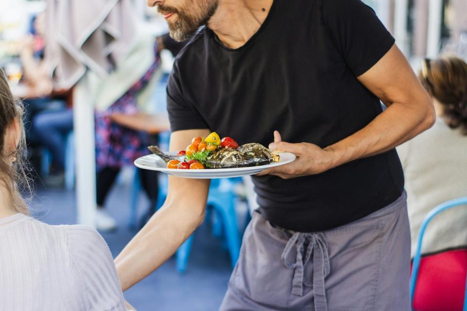 Waiter serving a plate in a restaurant