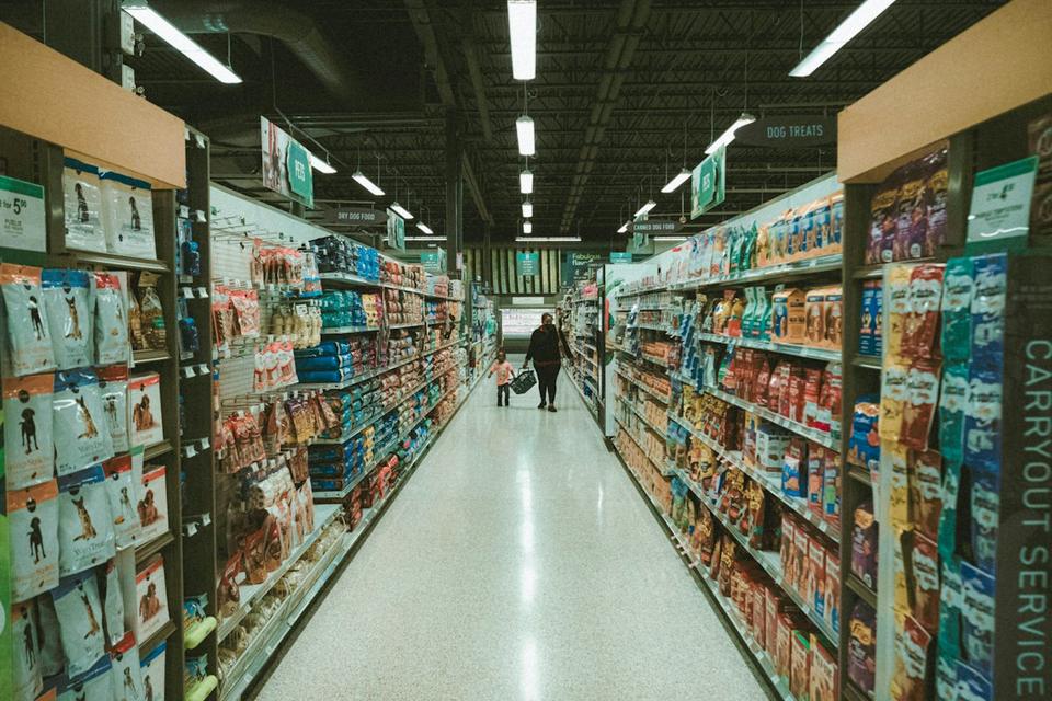 Shopper walking down a supermarket aisle